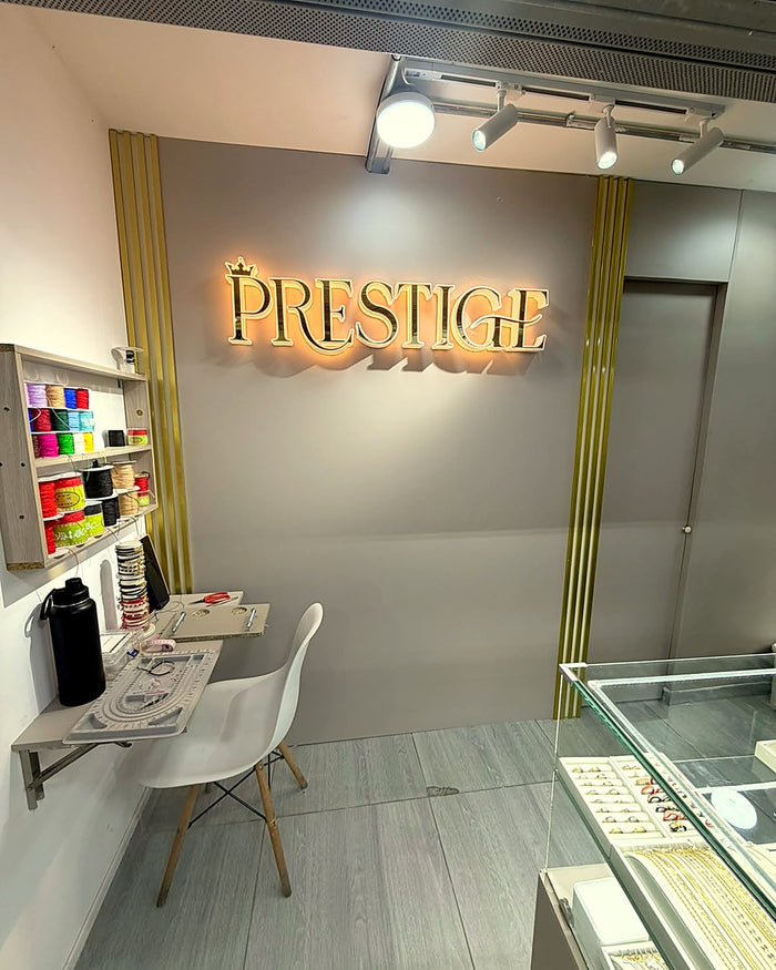Letrero de Prestige y mesa donde armamos las joyas